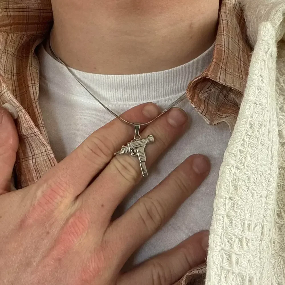 Flat lay silver uzi pendant